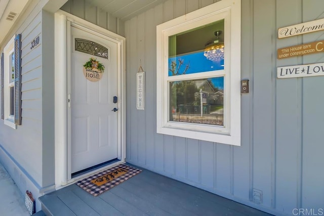 property entrance featuring visible vents and board and batten siding