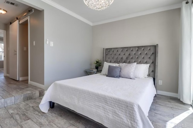 bedroom featuring a barn door, visible vents, baseboards, ornamental molding, and an inviting chandelier