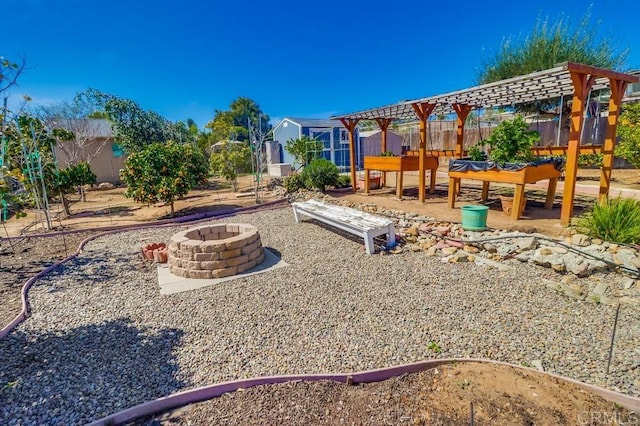 view of play area featuring a patio area, fence, a fire pit, and a pergola