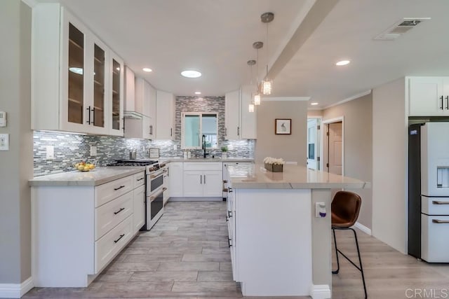 kitchen featuring white appliances, a sink, a kitchen island, visible vents, and tasteful backsplash