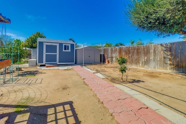 view of yard with a patio area, a shed, an outdoor structure, and a fenced backyard