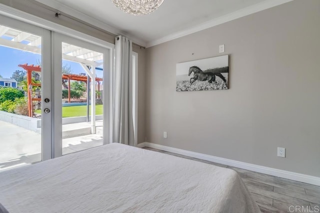 bedroom with baseboards, wood finished floors, access to outside, crown molding, and french doors