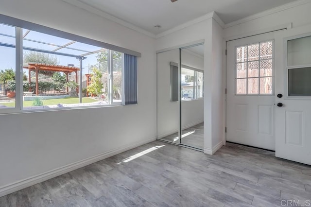 interior space featuring crown molding, baseboards, and wood finished floors