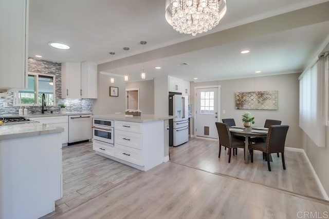 kitchen with light wood-type flooring, white appliances, tasteful backsplash, and white cabinetry