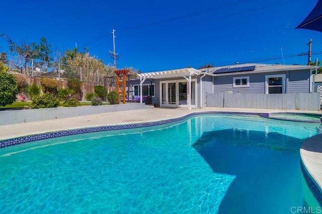 view of pool with an in ground hot tub, fence, french doors, a patio area, and a pergola