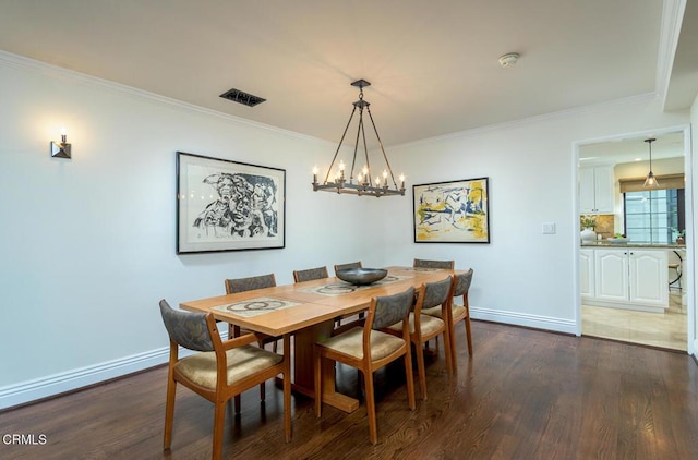 dining room with visible vents, baseboards, dark wood finished floors, and crown molding