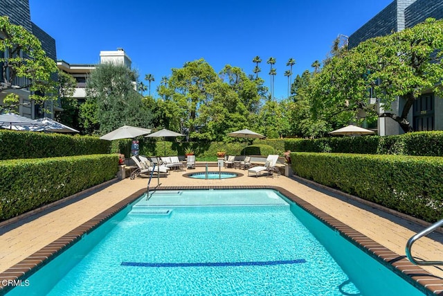 community pool with a patio area and a community hot tub