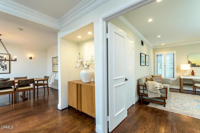 hallway featuring ornamental molding, dark wood finished floors, recessed lighting, an inviting chandelier, and baseboards