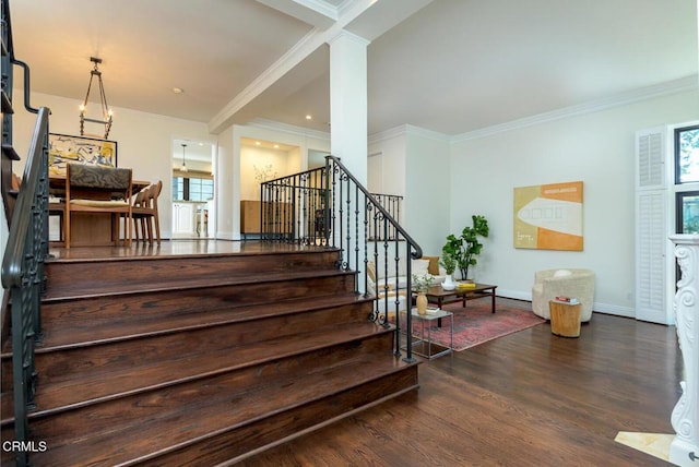 stairs featuring plenty of natural light, wood finished floors, baseboards, and ornamental molding