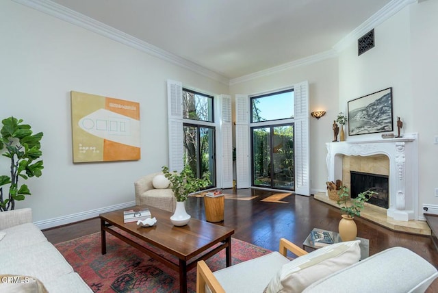 living room with a high end fireplace, visible vents, crown molding, baseboards, and wood finished floors