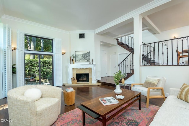 living area with visible vents, ornamental molding, stairs, and wood finished floors