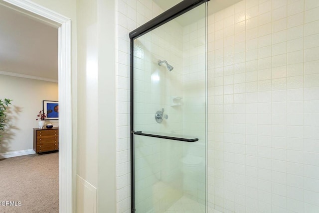 bathroom featuring tiled shower, crown molding, and baseboards