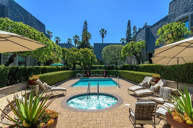 pool with a patio and a community hot tub