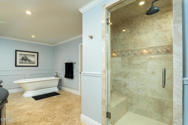 full bath featuring a wainscoted wall, a stall shower, a freestanding bath, crown molding, and a decorative wall