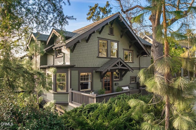 view of front of house with roof with shingles and a wooden deck