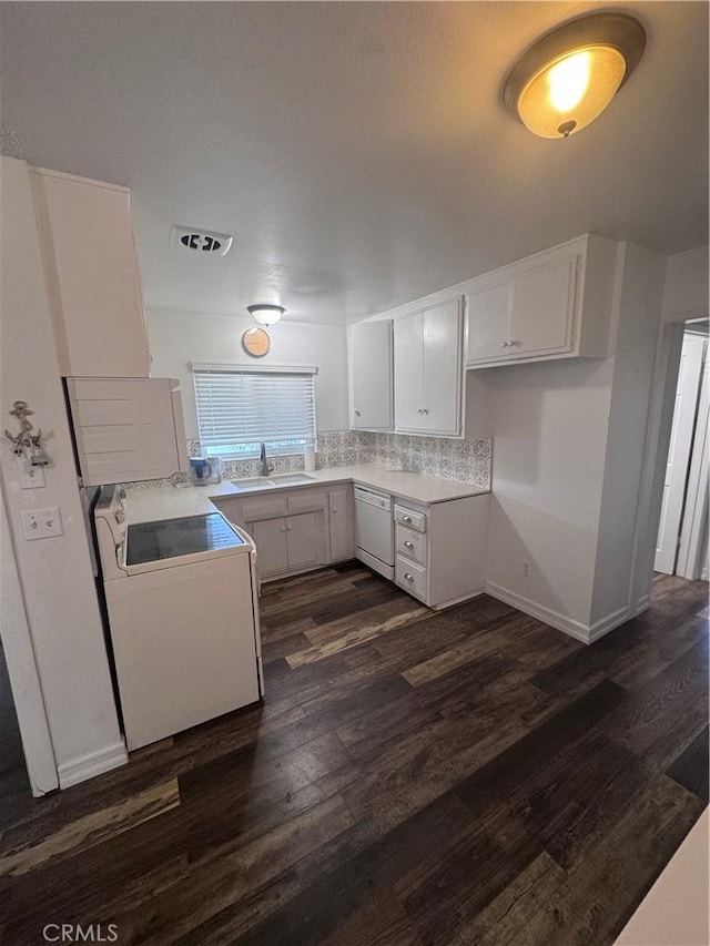 kitchen with a sink, white cabinetry, range, dishwasher, and dark wood-style flooring