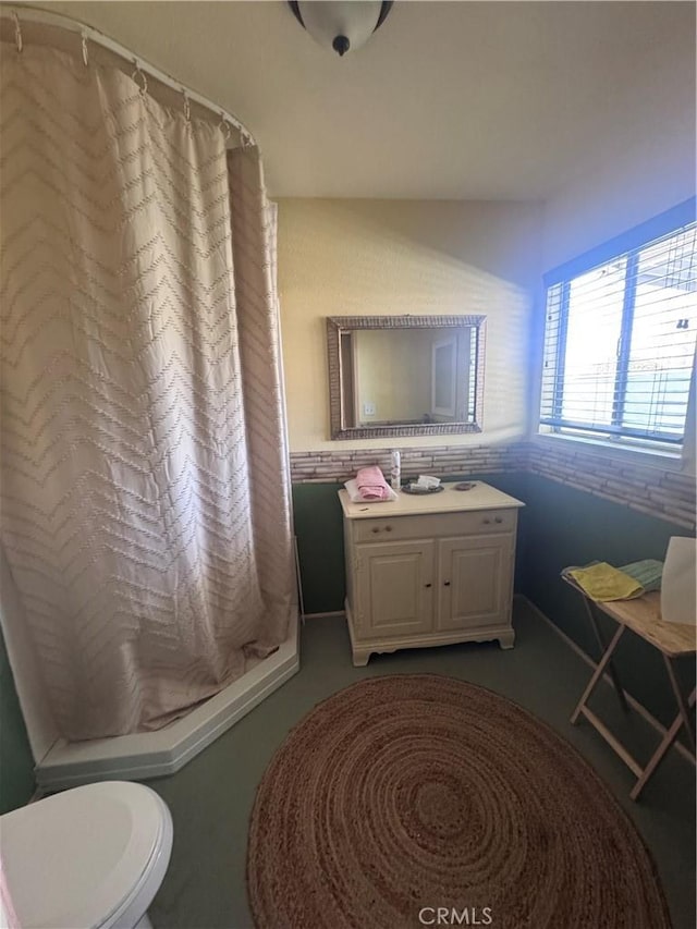 bathroom with a shower with curtain, toilet, and vanity