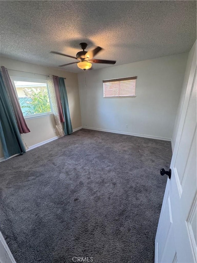 unfurnished room featuring a ceiling fan, baseboards, carpet floors, and a textured ceiling