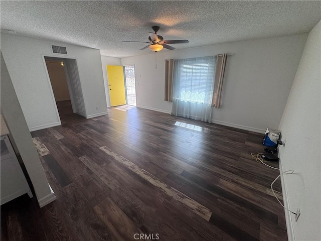 empty room featuring visible vents, baseboards, a textured ceiling, and wood finished floors