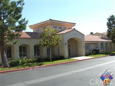 mediterranean / spanish-style home featuring a tiled roof and stucco siding