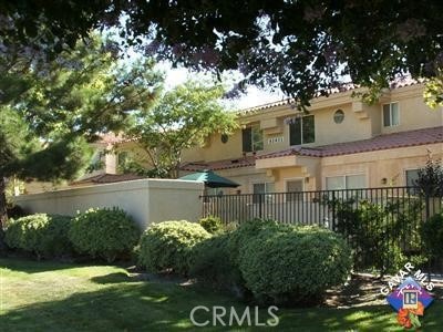 view of front of house featuring a front yard, fence, and stucco siding