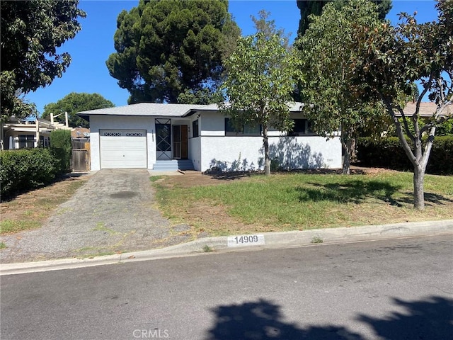 view of front facade with an attached garage, fence, driveway, stucco siding, and a front lawn