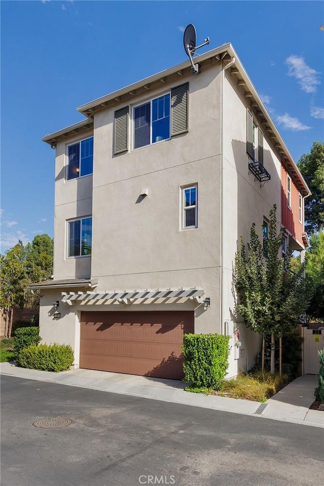 view of property exterior with an attached garage and stucco siding