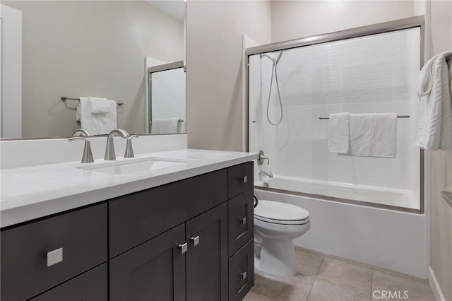 full bath featuring toilet, combined bath / shower with glass door, vanity, and tile patterned floors