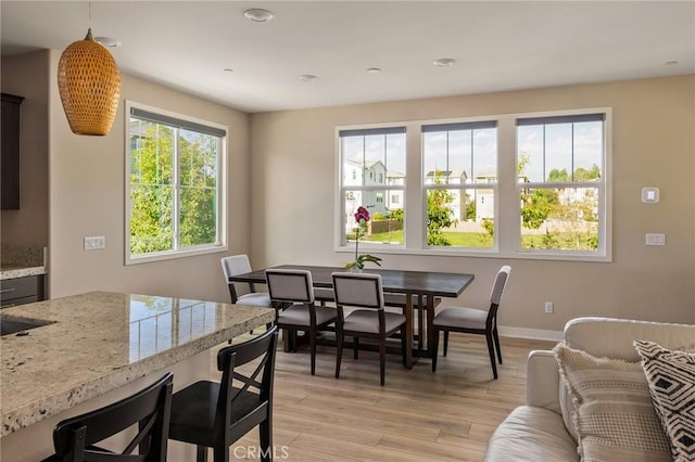 dining area with light wood-style flooring and baseboards