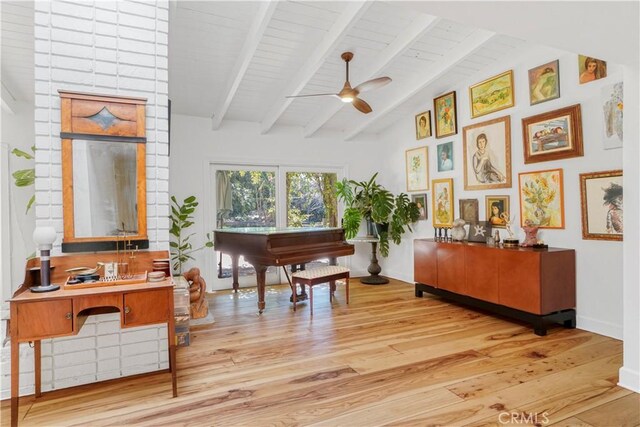 sitting room with lofted ceiling with beams, baseboards, a ceiling fan, and wood finished floors