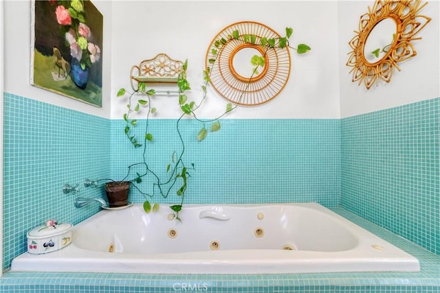 full bath featuring tile walls and a whirlpool tub