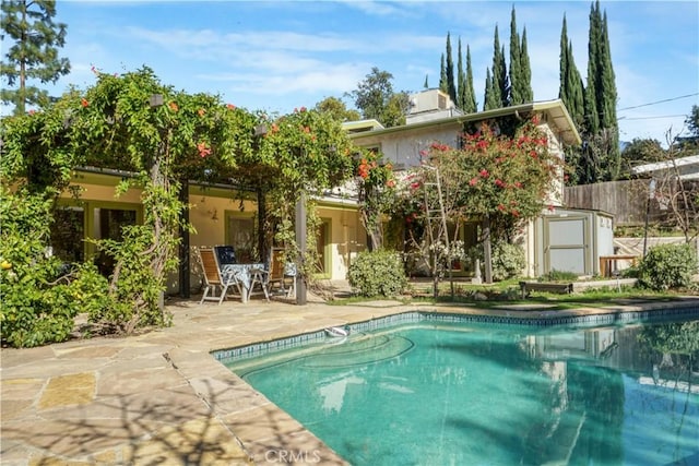 outdoor pool with fence and a patio