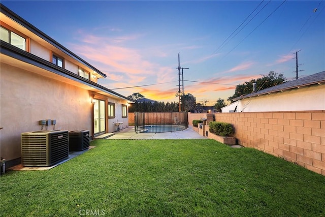 view of yard featuring a patio, a fenced backyard, and central air condition unit