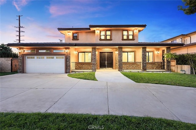 prairie-style house featuring covered porch, driveway, an attached garage, and stucco siding