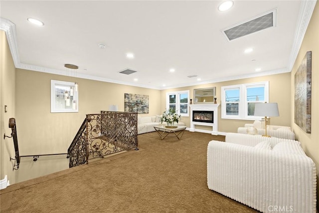 carpeted living room featuring ornamental molding, a glass covered fireplace, visible vents, and recessed lighting