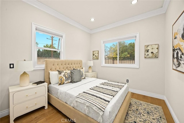 bedroom featuring multiple windows, wood finished floors, and crown molding