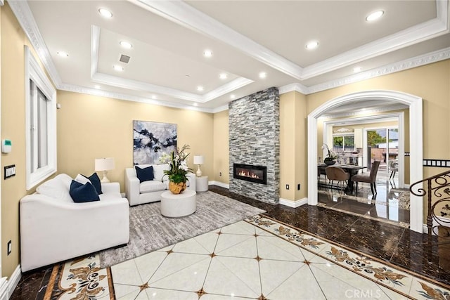 living area featuring a tray ceiling, crown molding, baseboards, and recessed lighting