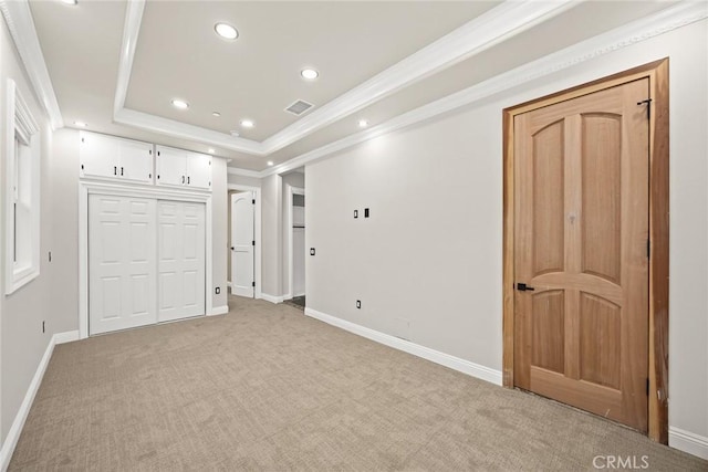 unfurnished bedroom with recessed lighting, light colored carpet, baseboards, a tray ceiling, and crown molding