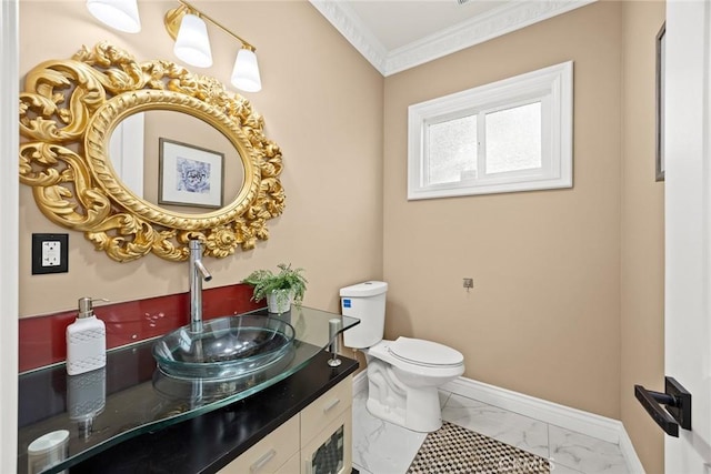 bathroom featuring marble finish floor, crown molding, toilet, vanity, and baseboards