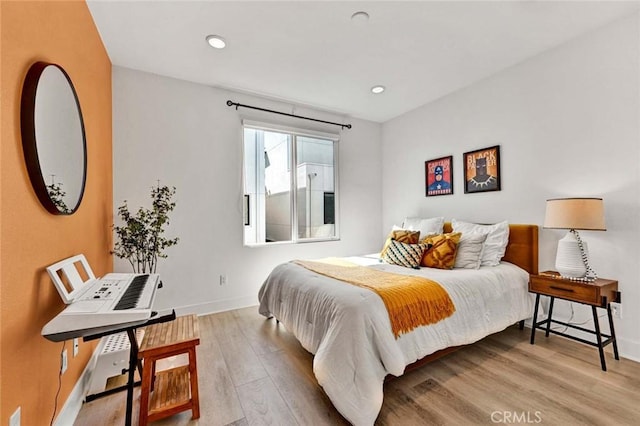 bedroom with recessed lighting, wood finished floors, and baseboards