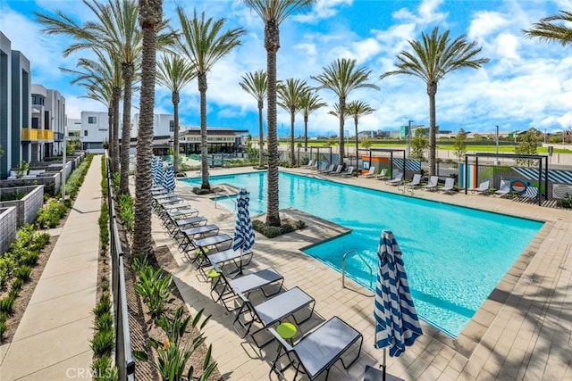 community pool with a patio area and fence