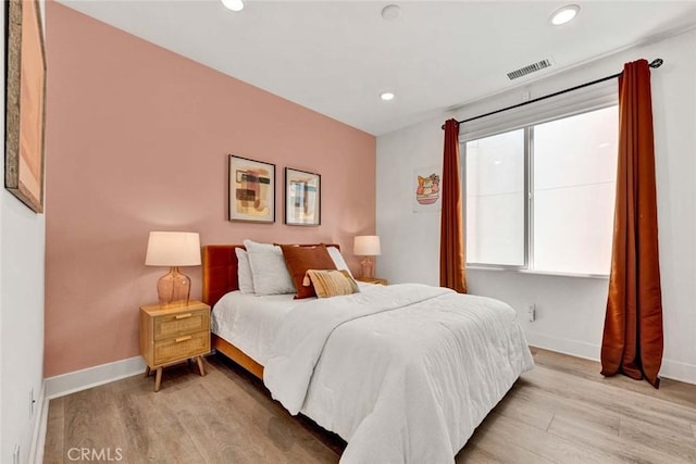 bedroom with baseboards, recessed lighting, visible vents, and light wood-style floors