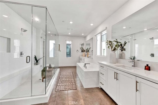 full bath featuring two vanities, a stall shower, a sink, a bath, and tile patterned floors