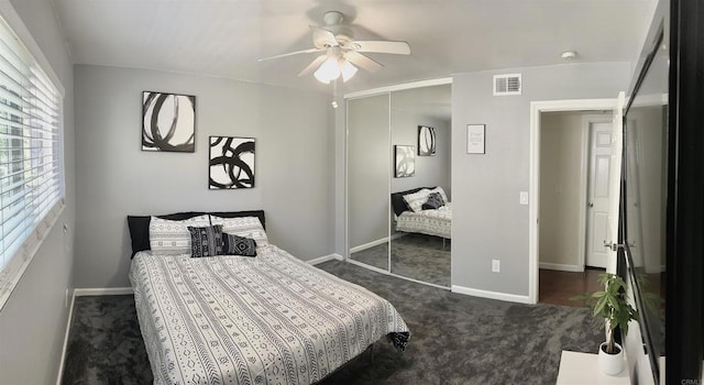 bedroom featuring a closet, dark carpet, visible vents, and baseboards