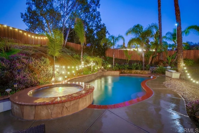 view of swimming pool featuring a pool with connected hot tub, a fenced backyard, and a patio