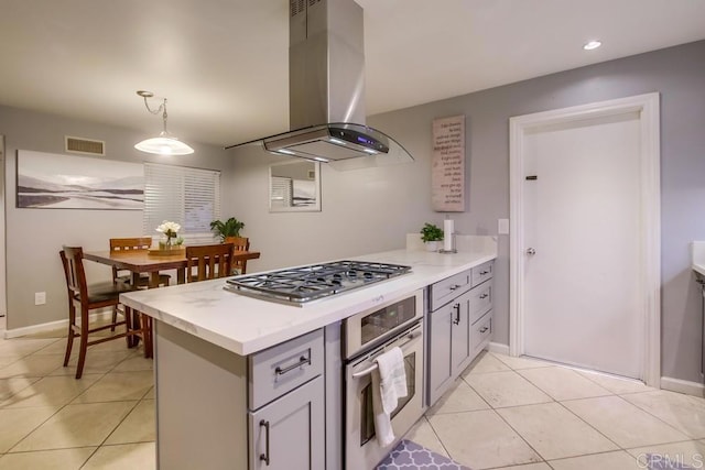 kitchen featuring island exhaust hood, light countertops, visible vents, appliances with stainless steel finishes, and light tile patterned flooring