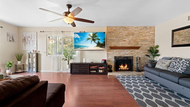 living area with ceiling fan, a fireplace, and wood finished floors