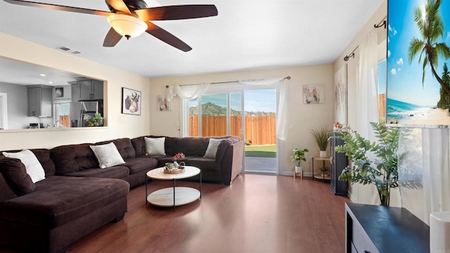 living area with visible vents, ceiling fan, and wood finished floors