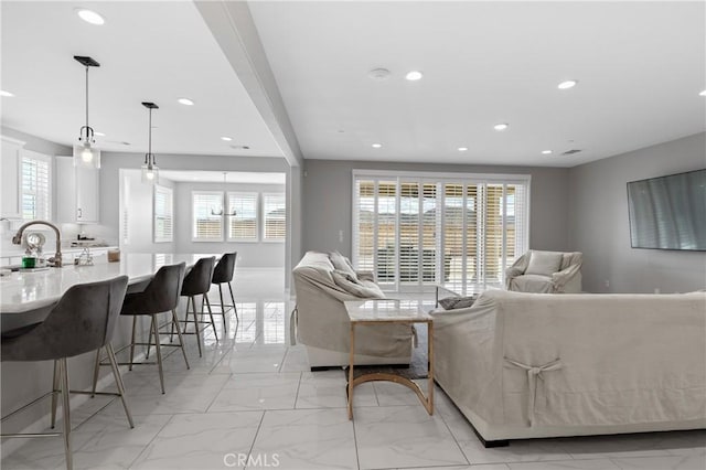 living room featuring a wealth of natural light, recessed lighting, and marble finish floor