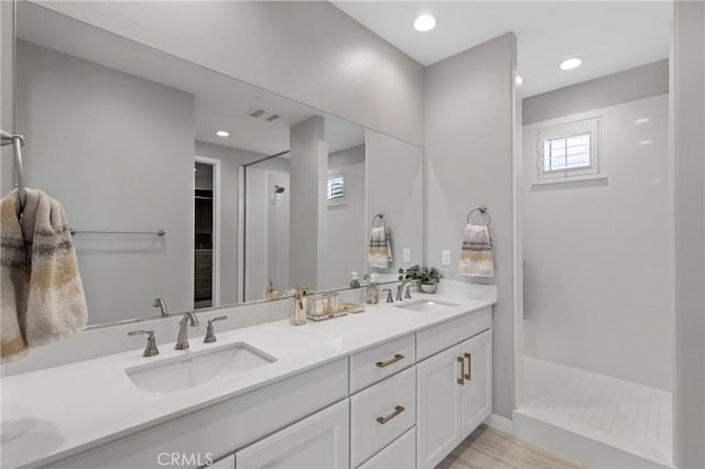 29945 Urtica Ct, Menifee, CA 92584 - bathroom with double vanity, walk in shower, visible vents, and a sink